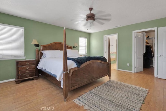 14908 Dakota Rd, Apple Valley, CA 92307 - bedroom with light wood-style floors, a spacious closet, a ceiling fan, and connected bathroom