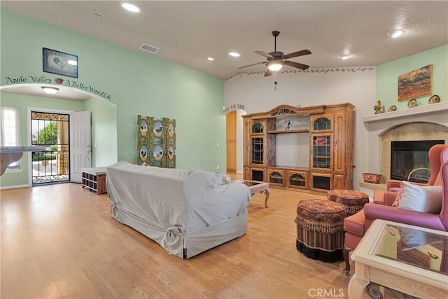 14908 Dakota Rd, Apple Valley, CA 92307 - living room featuring recessed lighting, a ceiling fan, a tiled fireplace, wood finished floors, and arched walkways
