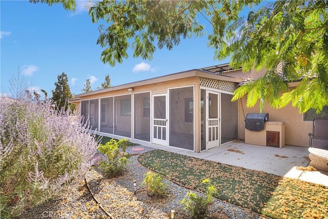 14908 Dakota Rd, Apple Valley, CA 92307 - back of property featuring a sunroom, stucco siding, and a patio