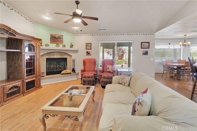 14908 Dakota Rd, Apple Valley, CA 92307 - living room featuring a ceiling fan, wood finished floors, a fireplace, and a chandelier