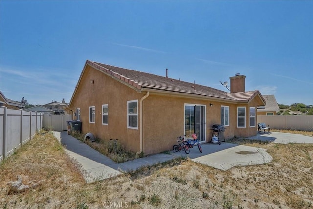 32124 Evening Primrose Trl, Campo, CA 91906 - rear view of house featuring a patio area, a chimney, a fenced backyard, stucco siding, and a tiled roof