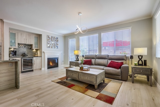 373 W Pebble Creek Ln, Orange, CA 92865 - living room featuring wine cooler, light wood-style floors, crown molding, and a glass covered fireplace