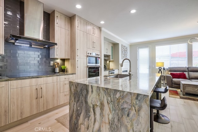 373 W Pebble Creek Ln, Orange, CA 92865 - kitchen featuring wall chimney exhaust hood, light brown cabinetry, a breakfast bar, light stone counters, and modern cabinets