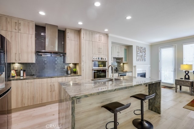 373 W Pebble Creek Ln, Orange, CA 92865 - kitchen with light brown cabinetry, wall chimney range hood, stainless steel appliances, modern cabinets, and crown molding