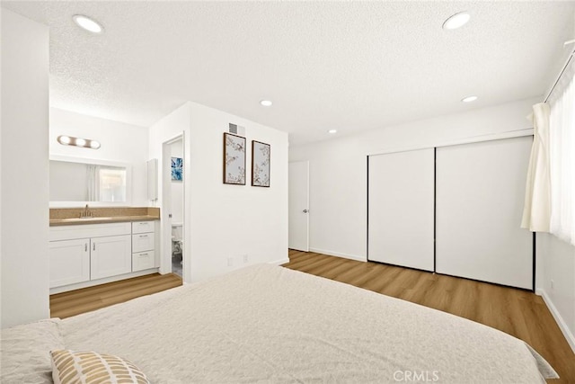 828 N Garfield Ave Unit C, Alhambra, CA 91801 - bedroom featuring wood finished floors, a textured ceiling, a closet, connected bathroom, and recessed lighting