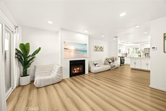 828 N Garfield Ave Unit C, Alhambra, CA 91801 - living area featuring light wood finished floors, a glass covered fireplace, and recessed lighting