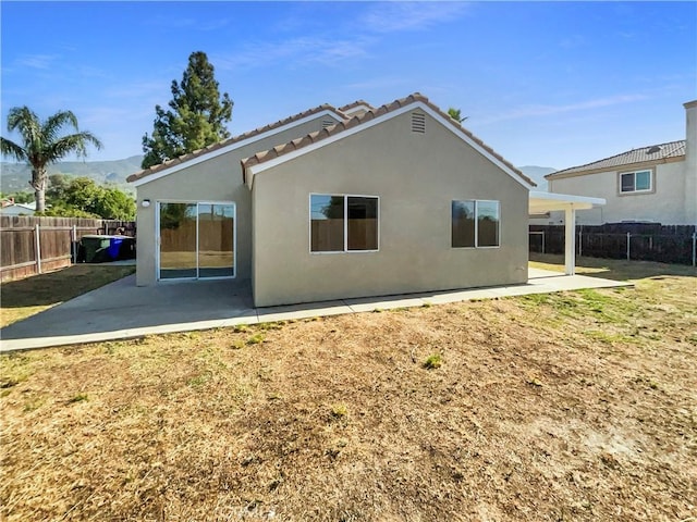 995 Northpark Blvd, San Bernardino, CA 92407 - rear view of house with stucco siding, a patio area, a tiled roof, and a mountain view