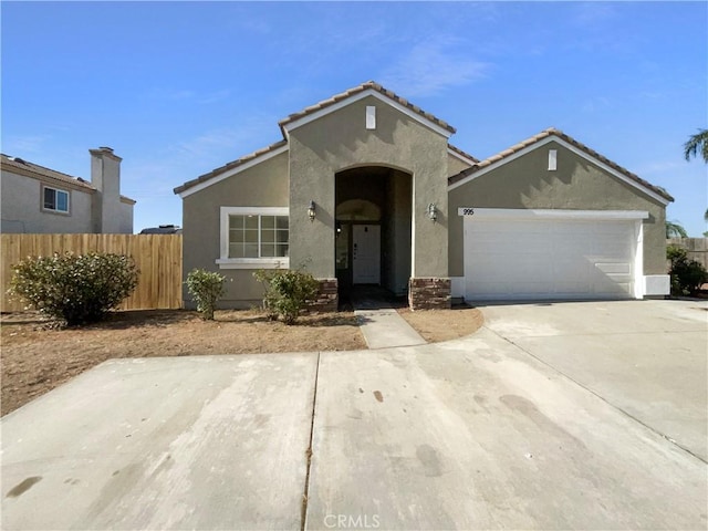 995 Northpark Blvd, San Bernardino, CA 92407 - view of front of house featuring stucco siding, an attached garage, driveway, and a tiled roof