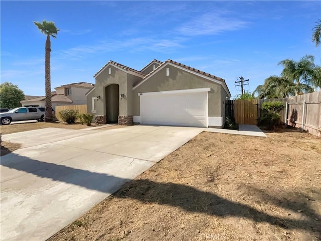 995 Northpark Blvd, San Bernardino, CA 92407 - view of front of home featuring stucco siding, concrete driveway, an attached garage, and a tile roof