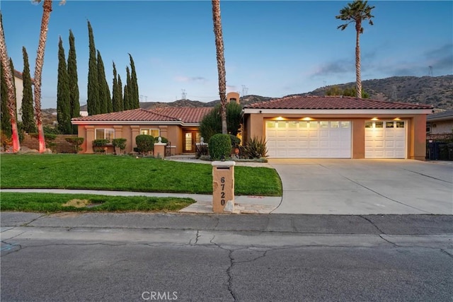 6720 Sycamore Ln, Palmdale, CA 93551 - view of front of home with a tiled roof, a front lawn, concrete driveway, stucco siding, and a garage