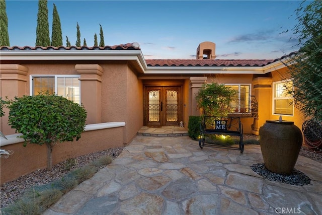 6720 Sycamore Ln, Palmdale, CA 93551 - property entrance with french doors, a tile roof, stucco siding, and a patio area