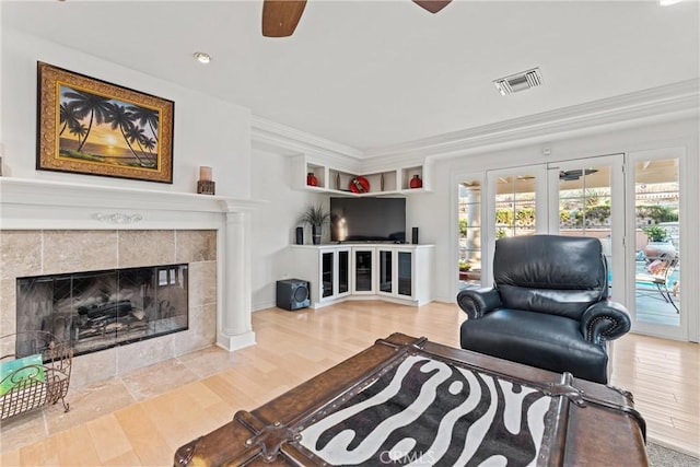 6720 Sycamore Ln, Palmdale, CA 93551 - living area featuring ceiling fan, wood finished floors, crown molding, a tiled fireplace, and plenty of natural light