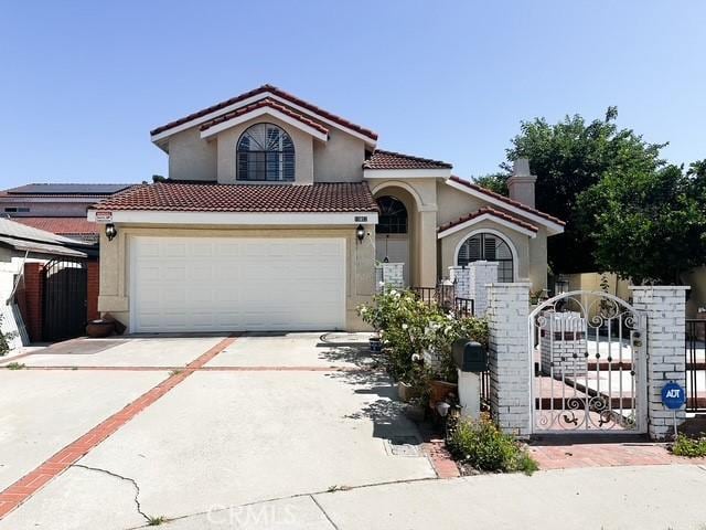 10452 Circulo De Juarez, Fountain Valley, CA 92708 - mediterranean / spanish house featuring stucco siding, driveway, a gate, and a tile roof