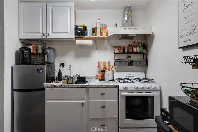 215 E 11th St Unit 4, Pomona, CA 91766 - kitchen featuring white gas stove, freestanding refrigerator, black microwave, white cabinets, and open shelves
