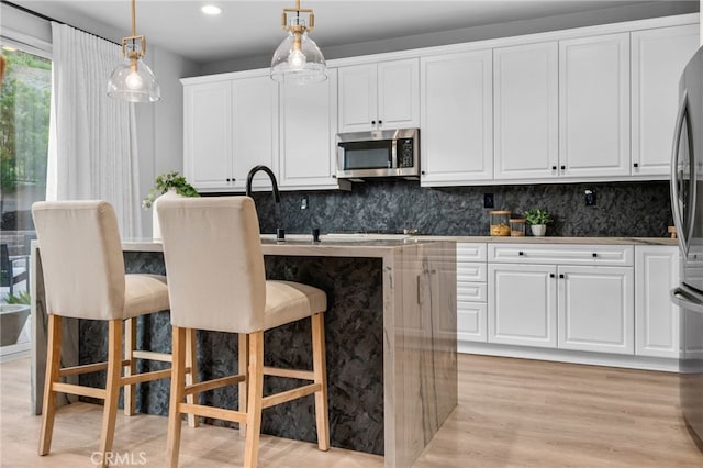 11824 Stonefield Dr, Corona, CA 92883 - kitchen featuring stainless steel appliances, white cabinets, tasteful backsplash, hanging light fixtures, and recessed lighting