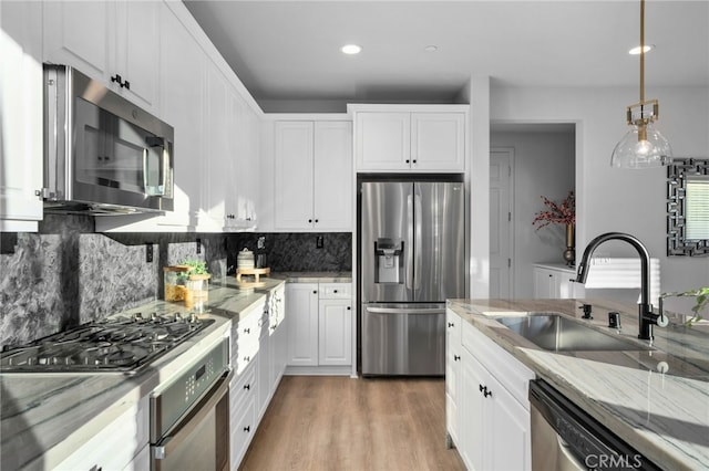 11824 Stonefield Dr, Corona, CA 92883 - kitchen with stainless steel appliances, white cabinetry, tasteful backsplash, light wood-type flooring, and light stone countertops