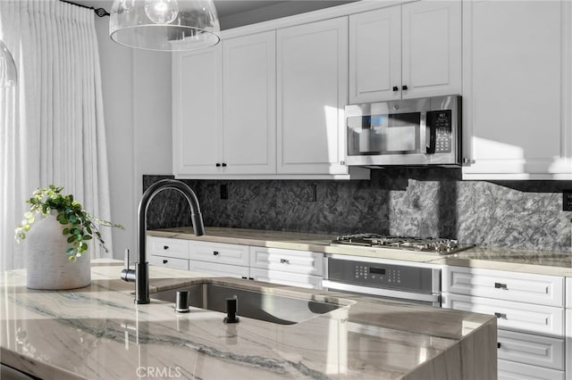 11824 Stonefield Dr, Corona, CA 92883 - kitchen with appliances with stainless steel finishes, white cabinets, light stone countertops, and backsplash