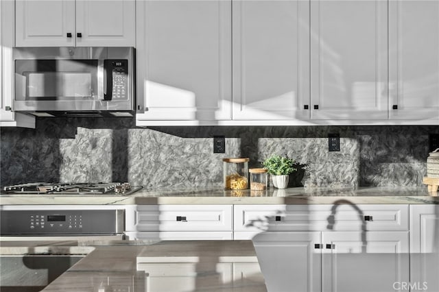 11824 Stonefield Dr, Corona, CA 92883 - kitchen featuring appliances with stainless steel finishes, white cabinetry, and tasteful backsplash