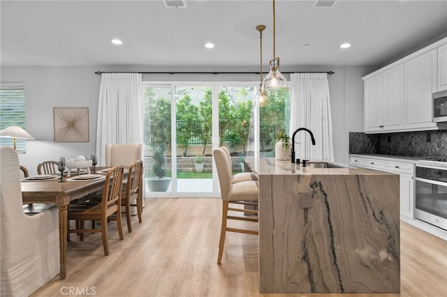11824 Stonefield Dr, Corona, CA 92883 - kitchen featuring stainless steel appliances, healthy amount of natural light, a kitchen island with sink, light wood-style floors, and recessed lighting