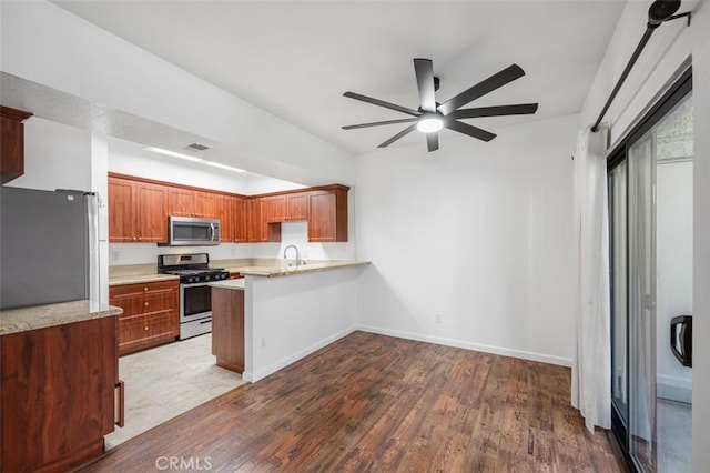 4822 Tiara Dr Unit 104, Huntington Beach, CA 92649 - kitchen with stainless steel appliances, a ceiling fan, a peninsula, light countertops, and wood finished floors