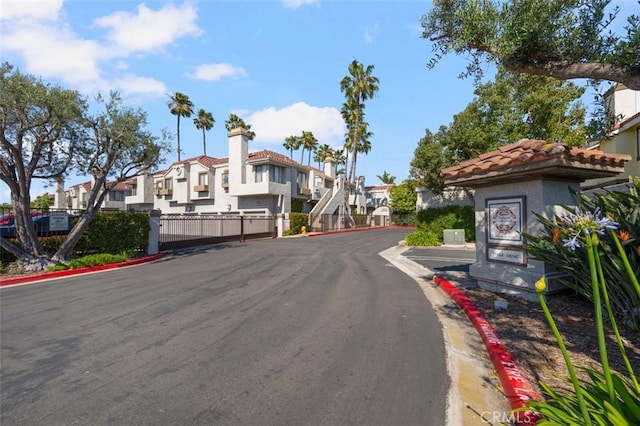 4822 Tiara Dr Unit 104, Huntington Beach, CA 92649 - view of asphalt street featuring a residential view, curbs, and a gate