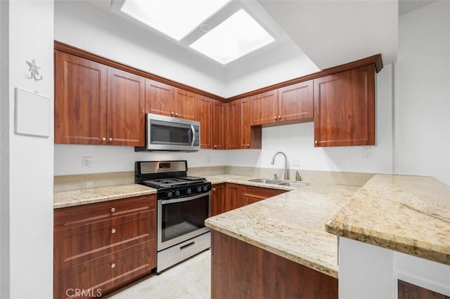 4822 Tiara Dr Unit 104, Huntington Beach, CA 92649 - kitchen featuring appliances with stainless steel finishes, a peninsula, and light stone counters