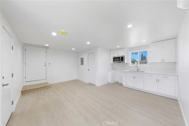 426 E 17th St, Long Beach, CA 90813 - kitchen with stainless steel microwave, white cabinetry, electric panel, light wood-style flooring, and recessed lighting