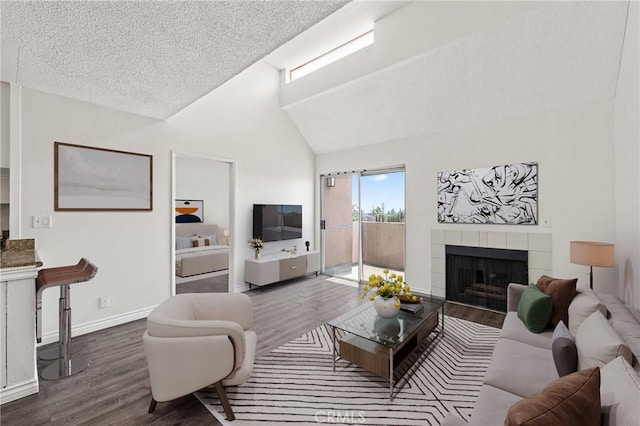 450 E 4th St Unit 419, Santa Ana, CA 92701 - living room featuring wood finished floors, a fireplace, lofted ceiling, and a textured ceiling