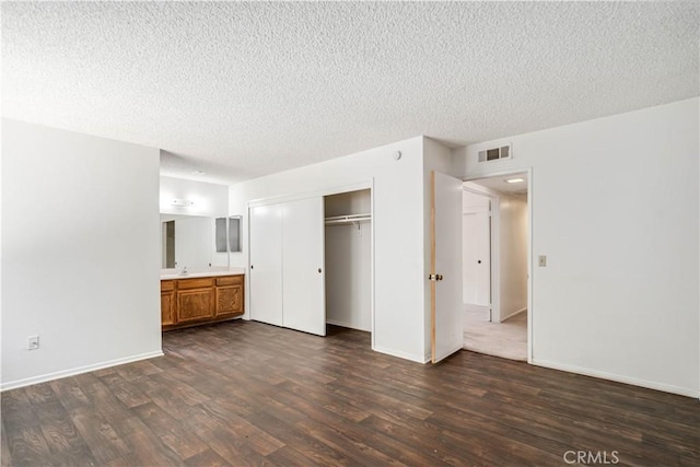 37224 Halfmoon Dr, Palmdale, CA 93550 - unfurnished bedroom with dark wood-style floors, a textured ceiling, a closet, and ensuite bathroom