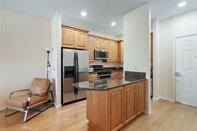 2750 Artesia Blvd Unit 313, Redondo Beach, CA 90278 - kitchen with appliances with stainless steel finishes, light wood finished floors, dark stone counters, recessed lighting, and a peninsula