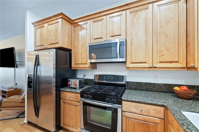 2750 Artesia Blvd Unit 313, Redondo Beach, CA 90278 - kitchen featuring stainless steel appliances, light wood finished floors, and dark stone countertops