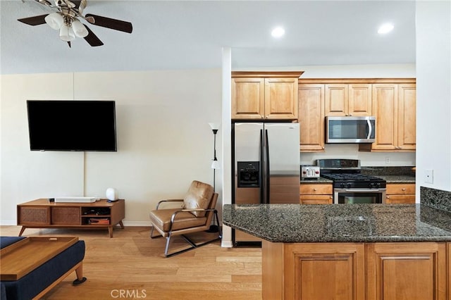 2750 Artesia Blvd Unit 313, Redondo Beach, CA 90278 - kitchen featuring appliances with stainless steel finishes, light wood-type flooring, a ceiling fan, dark stone counters, and a peninsula