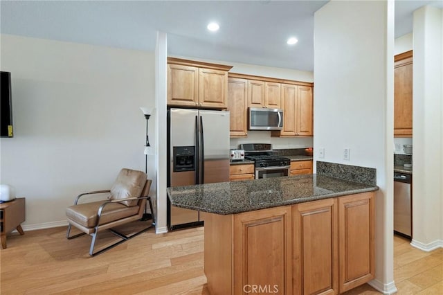 2750 Artesia Blvd Unit 313, Redondo Beach, CA 90278 - kitchen featuring appliances with stainless steel finishes, light wood-type flooring, dark stone counters, a peninsula, and recessed lighting