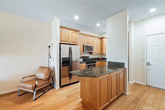 2750 Artesia Blvd Unit 313, Redondo Beach, CA 90278 - kitchen featuring appliances with stainless steel finishes, light wood finished floors, a peninsula, dark stone countertops, and recessed lighting