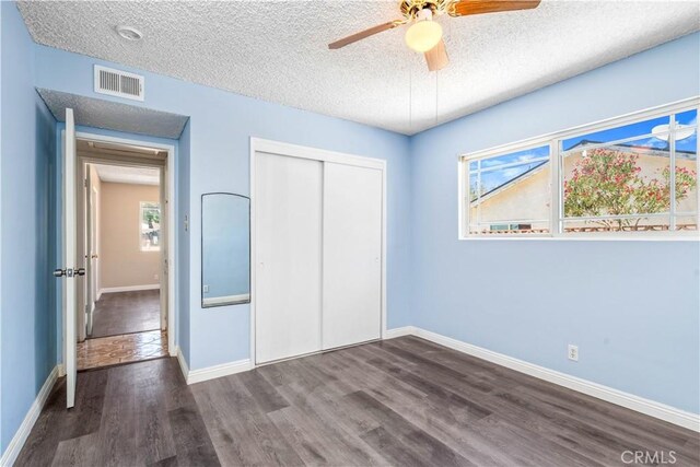 43236 W 20th St W, Lancaster, CA 93534 - unfurnished bedroom with wood finished floors, multiple windows, a closet, a textured ceiling, and ceiling fan