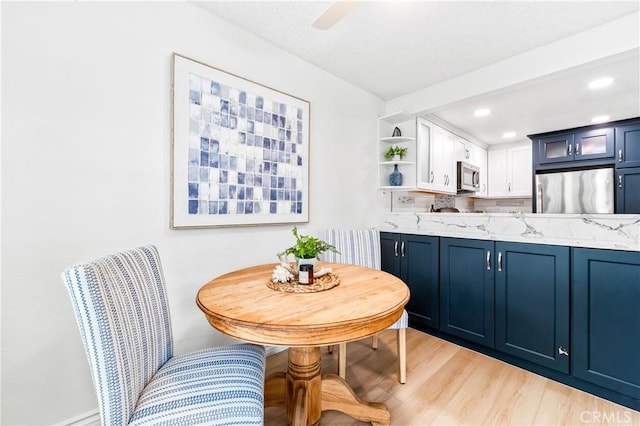 1442 Brett Pl Unit 31, San Pedro, CA 90732 - kitchen with stainless steel microwave, refrigerator, blue cabinets, open shelves, and recessed lighting