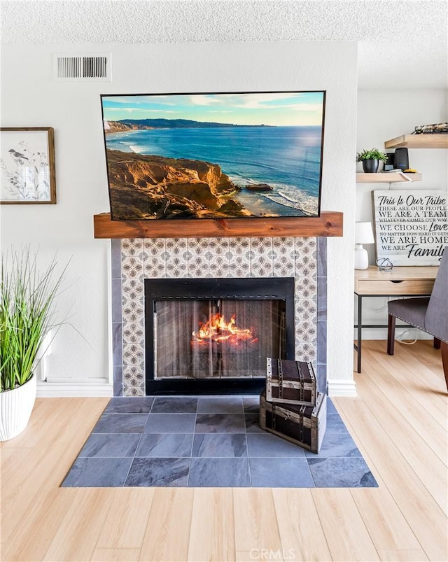 1442 Brett Pl Unit 31, San Pedro, CA 90732 - detailed view of a tile fireplace, wood finished floors, and a textured ceiling