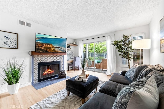 1442 Brett Pl Unit 31, San Pedro, CA 90732 - living room with a textured ceiling, a tiled fireplace, and wood finished floors