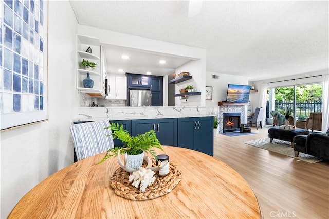 1442 Brett Pl Unit 31, San Pedro, CA 90732 - dining space with wood finished floors, a fireplace, a textured ceiling, and recessed lighting