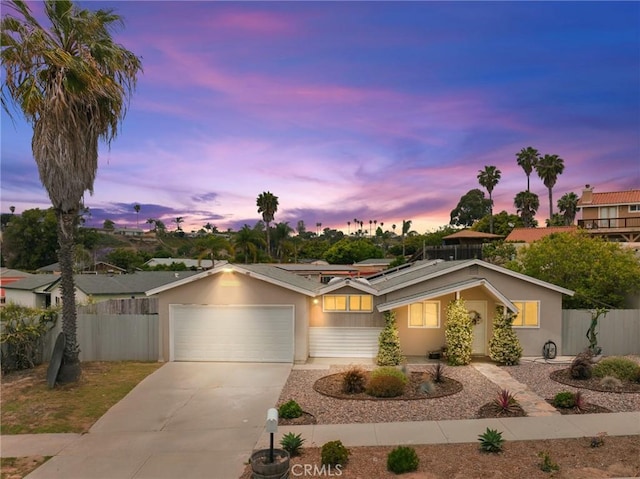4054 Lewis St, Oceanside, CA 92056 - view of front of house with concrete driveway, a garage, solar panels, and stucco siding