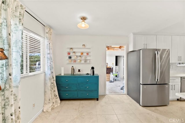 4054 Lewis St, Oceanside, CA 92056 - kitchen with freestanding refrigerator, white cabinetry, tasteful backsplash, and light tile patterned flooring