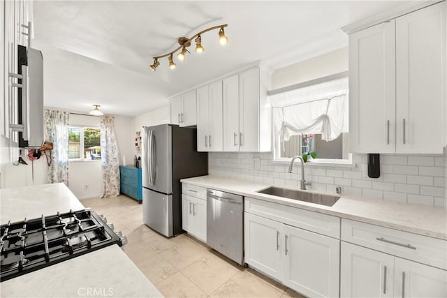 4054 Lewis St, Oceanside, CA 92056 - kitchen with appliances with stainless steel finishes, light countertops, white cabinetry, and decorative backsplash