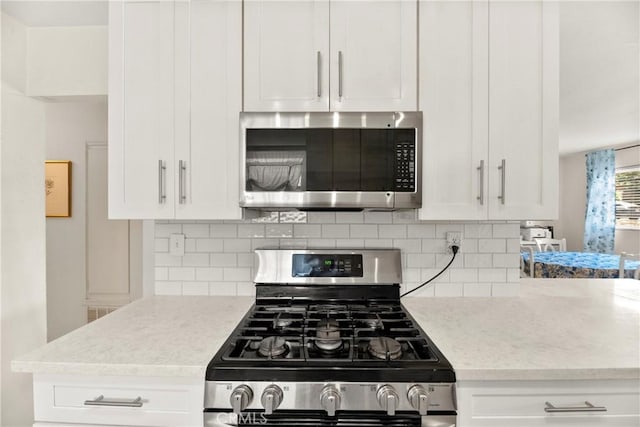 4054 Lewis St, Oceanside, CA 92056 - kitchen featuring stainless steel appliances, decorative backsplash, and white cabinets
