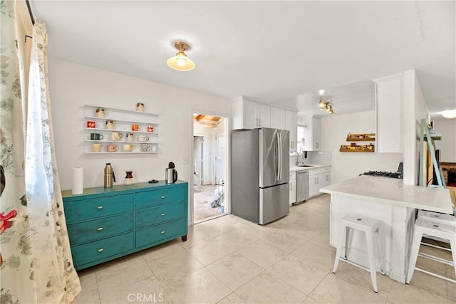 4054 Lewis St, Oceanside, CA 92056 - kitchen featuring appliances with stainless steel finishes, white cabinets, a peninsula, open shelves, and light countertops