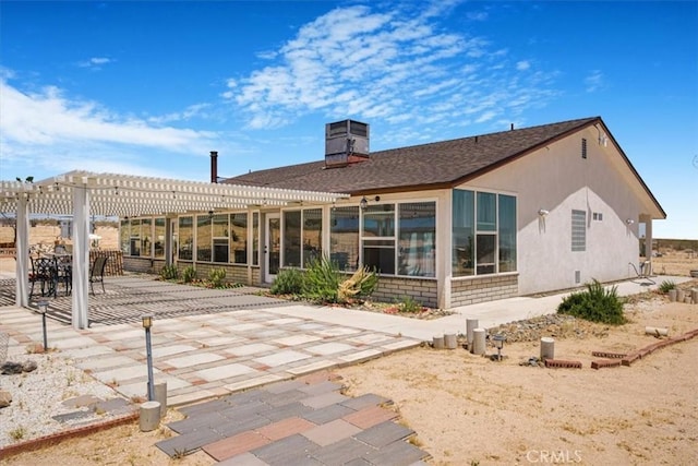 61975 La Brisa Dr, Joshua Tree, CA 92252 - rear view of property with a pergola, a patio area, a sunroom, and a chimney