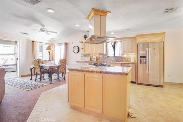 61975 La Brisa Dr, Joshua Tree, CA 92252 - kitchen with appliances with stainless steel finishes, light tile patterned flooring, a textured ceiling, light brown cabinets, and a kitchen island