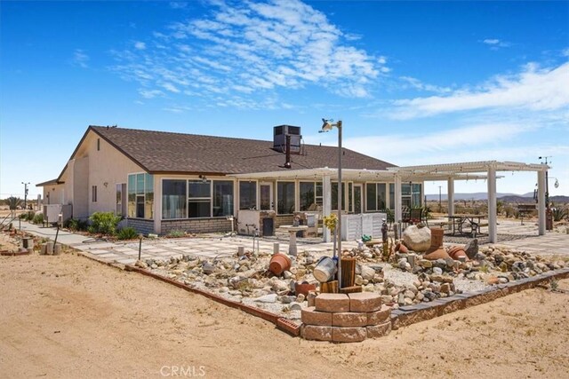 61975 La Brisa Dr, Joshua Tree, CA 92252 - back of property featuring a pergola, a sunroom, and roof with shingles