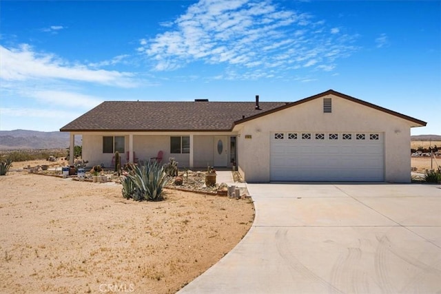61975 La Brisa Dr, Joshua Tree, CA 92252 - single story home featuring stucco siding, driveway, a garage, and a mountain view