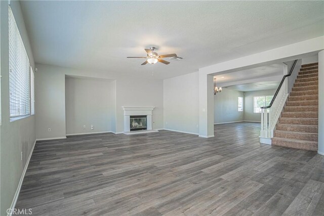 11935 Silver, Jurupa Valley, CA 91752 - unfurnished living room featuring ceiling fan, wood finished floors, stairway, a glass covered fireplace, and a chandelier