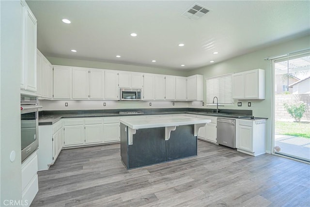 11935 Silver, Jurupa Valley, CA 91752 - kitchen with stainless steel appliances, a kitchen island, white cabinets, light wood-style flooring, and recessed lighting